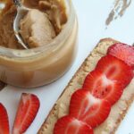 A delicious close-up of peanut butter and fresh strawberries on toast. Perfect for breakfast ideas.